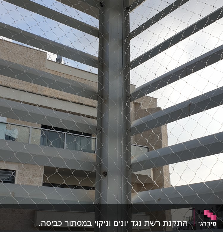 רשת מתכת מותקנת על מבנה למניעת כניסת יונים
